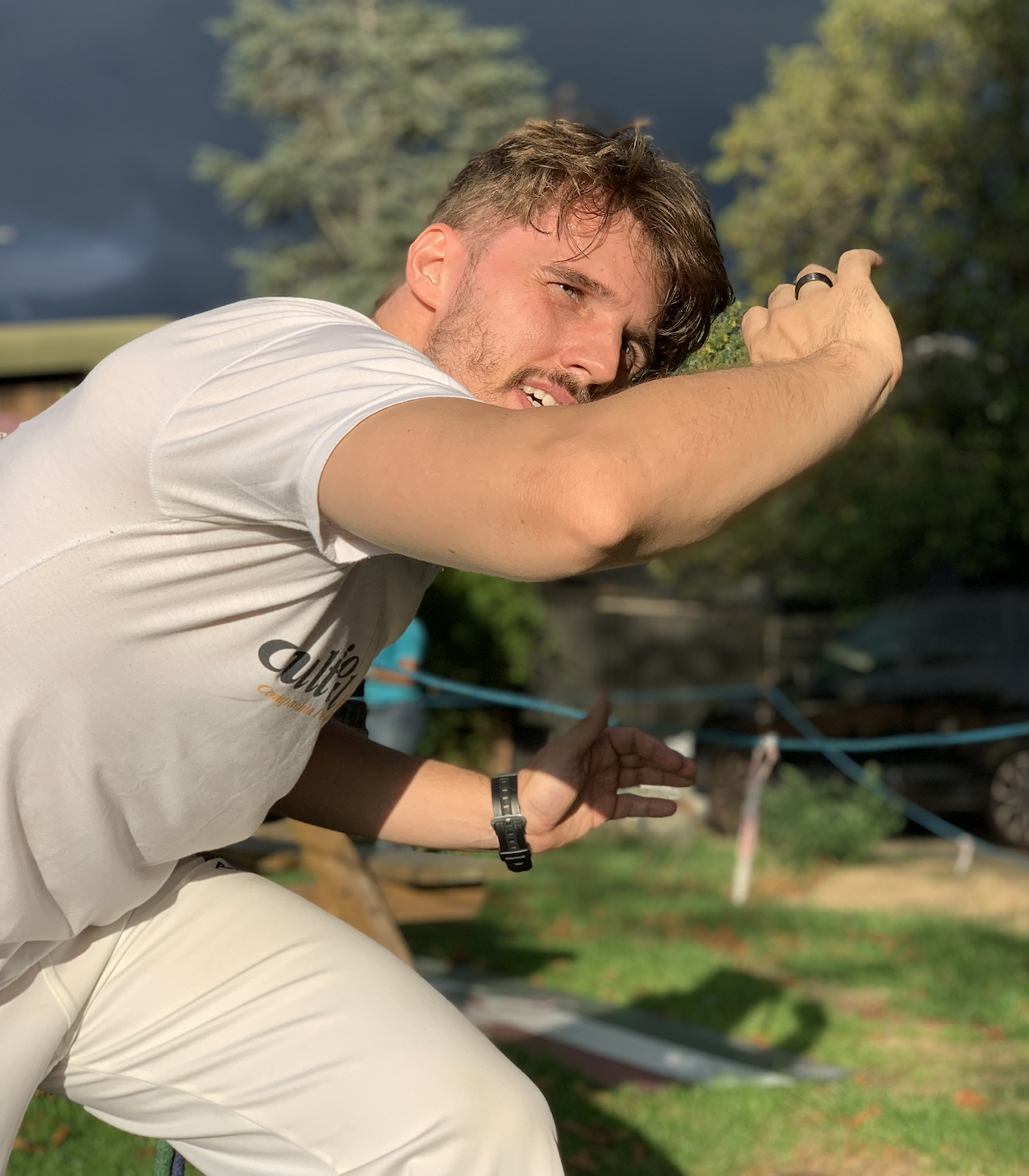 Instrutor Mateus Gato demonstrating a Capoeira movement outdoors